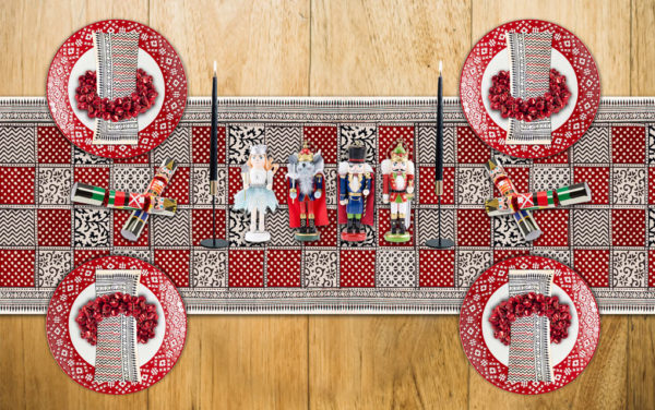 A colorful Christmas table set with a red Christmas table runner