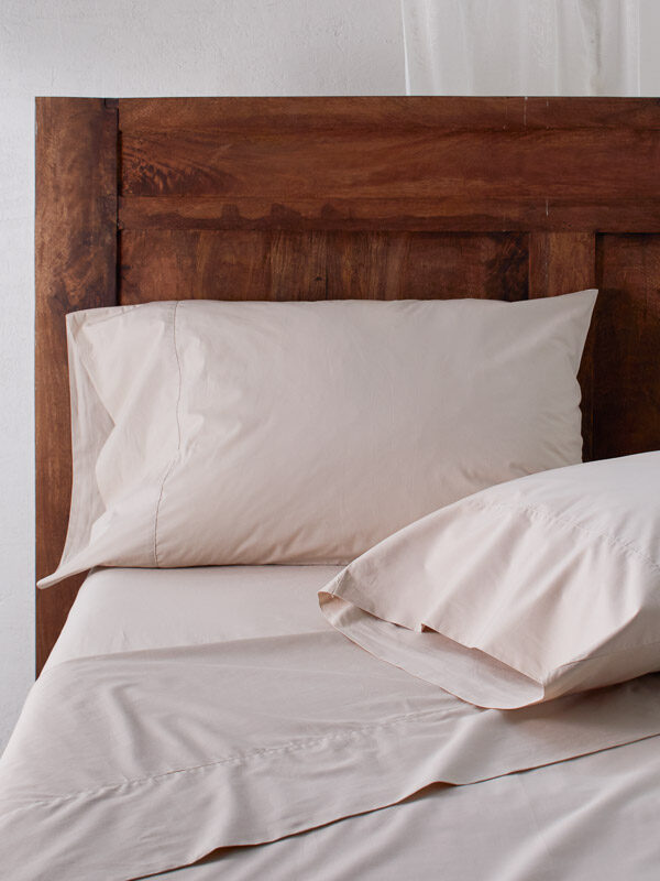 Natural color cotton sheet set with brown wood headboard