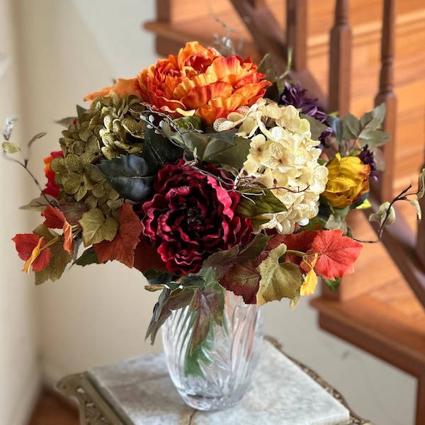 Fall floral bouquet in shades of orange, burgundy, and white to complement blue fall decor