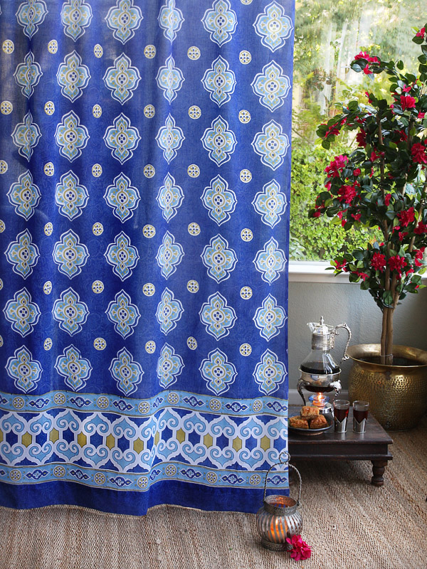 Moroccan curtains, like these blue curtains with a Moroccan print, create a global look at the window.