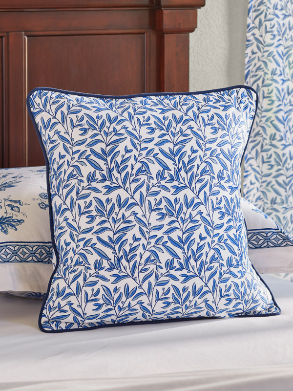 A blue throw pillow cover in a botanical print 