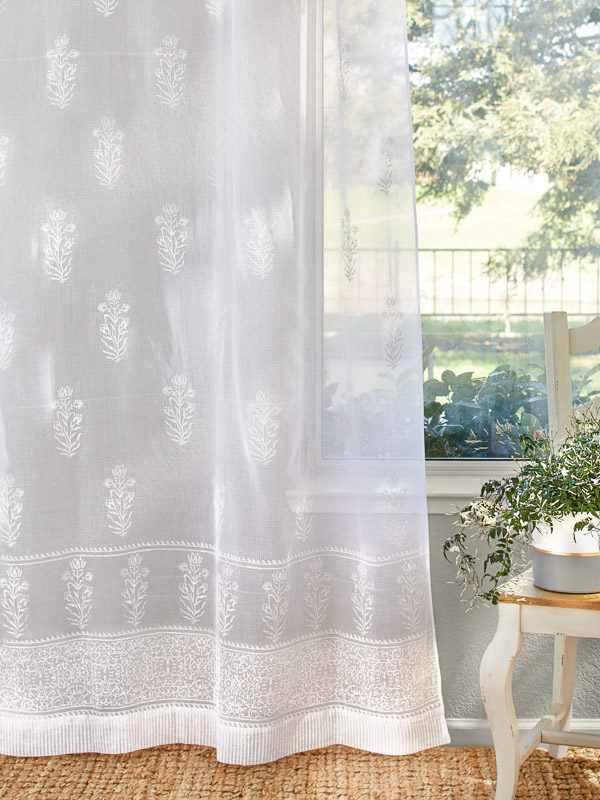White sheer curtains with a floral pattern are essential for your summer decor.