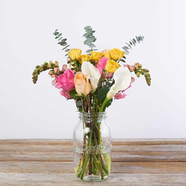 a floral bouquet with pink roses, peach tulips, calla liloes, and eucalyptus