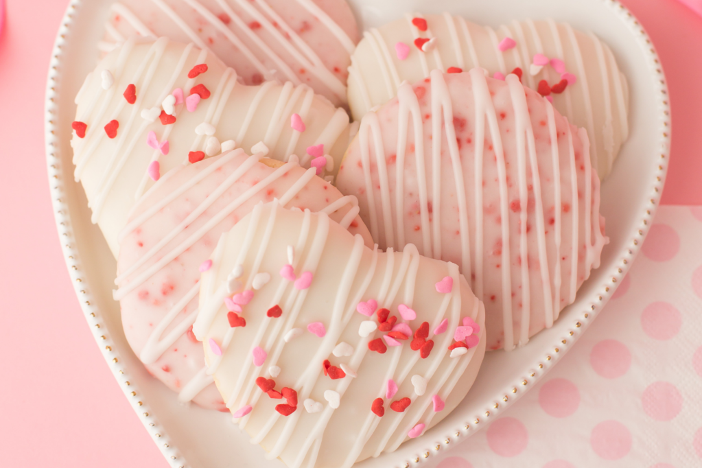 heart-shaped tea cakes with vanilla icing and heart-shaped pink and red spinkles for Valentine's day
