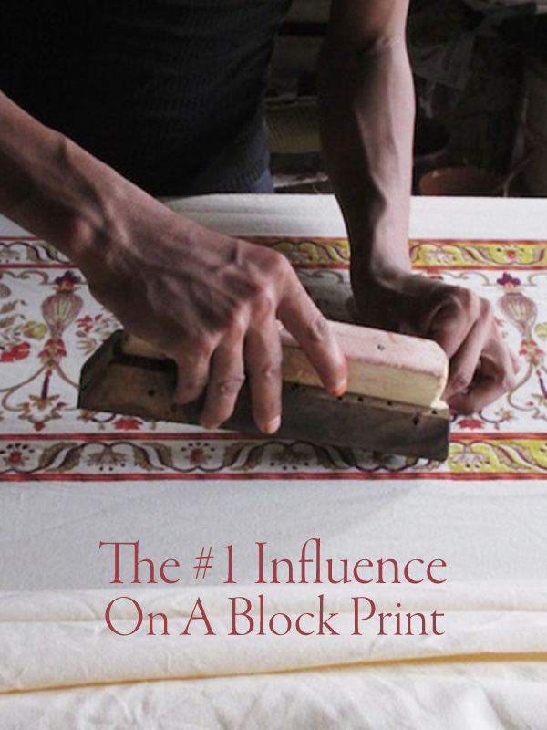 Hands stamping a wood block print with a sign that says "The #1 Influence On A Block Print"