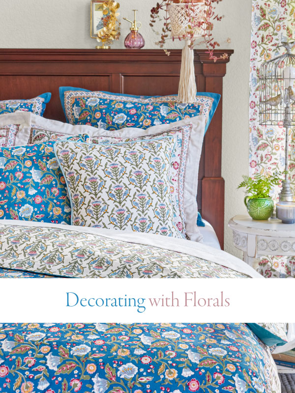 a bed made with floral bedding in blue and white and sign that says decorating with florals