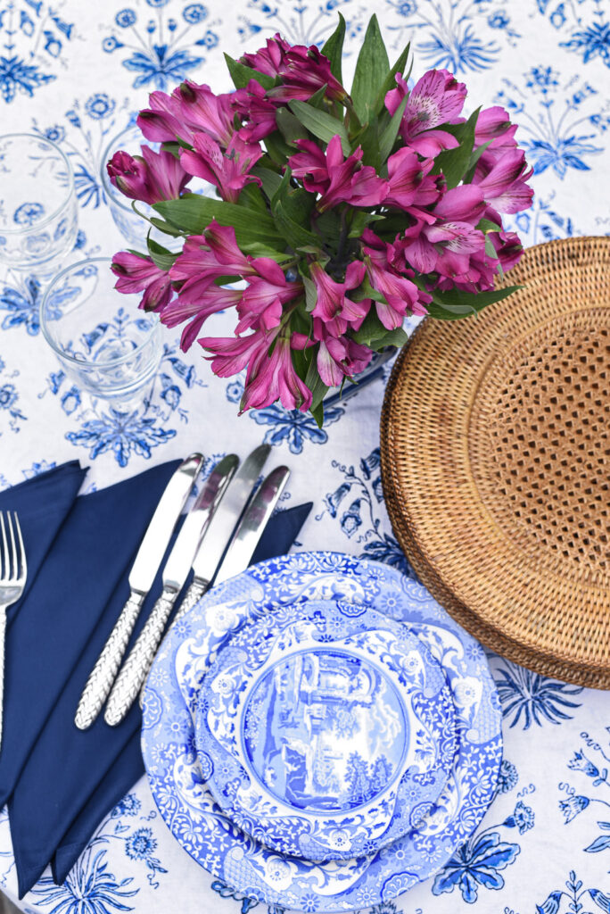 blue and white floral tablecloth with blue china and purple flowers