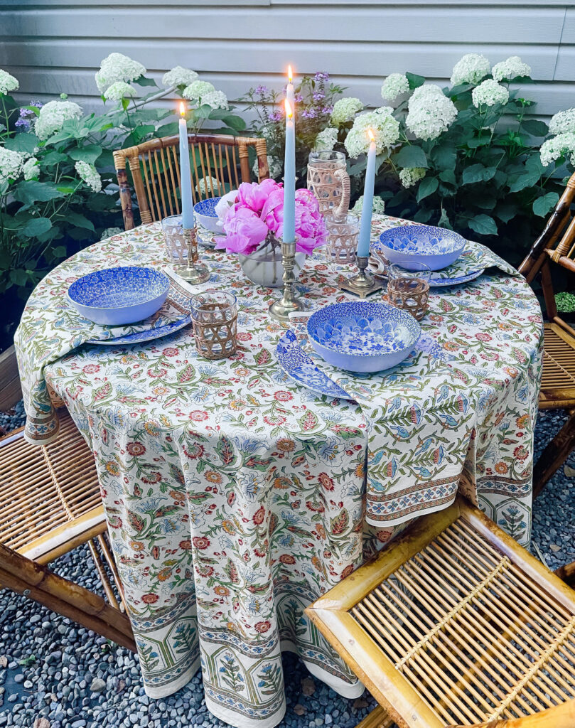 colorful elegant outdoor table setting with flowers and candles, pink and blue and white