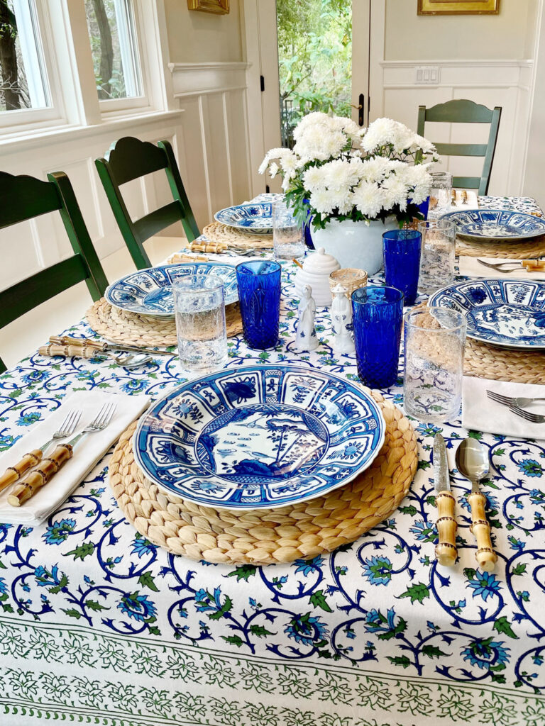 green, blue and white tablecloth with botanical floral pattern and white and blue tablescape