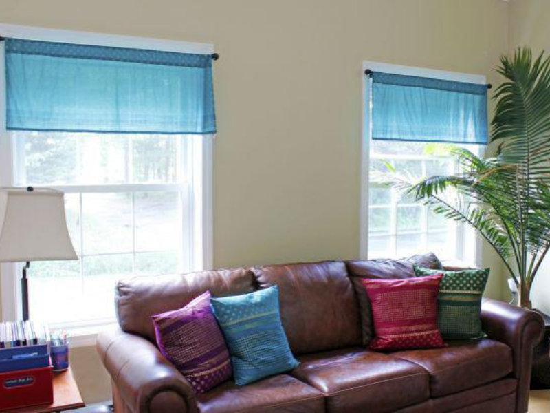 turquoise valances with beads, leather sofa, boho pillows with indian block prints