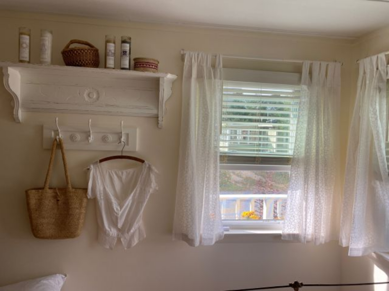 white sheer curtains with pattern hanging in the window of a mudroom