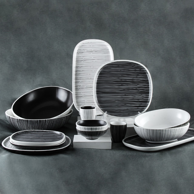 Black and white porcelain set with fine white lines, including serving bowls, platters, bowls, plates, and cups