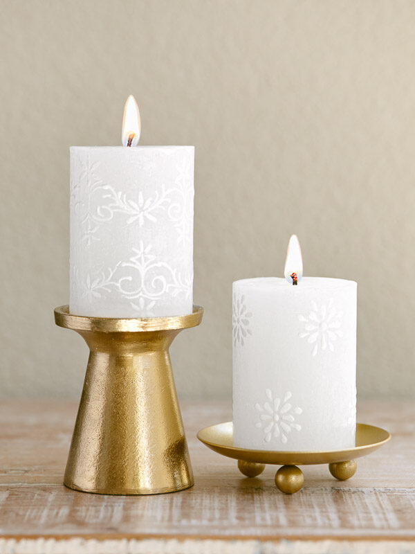 White filigree pillar candles that complement elegant Christmas table linens