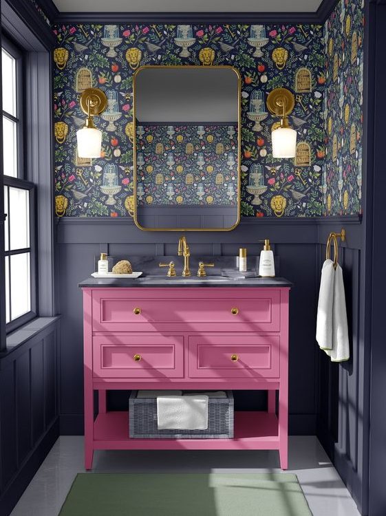 Picture of a bathroom with a pink vanity gold frame mirror, gray walls, and floral wallpaper