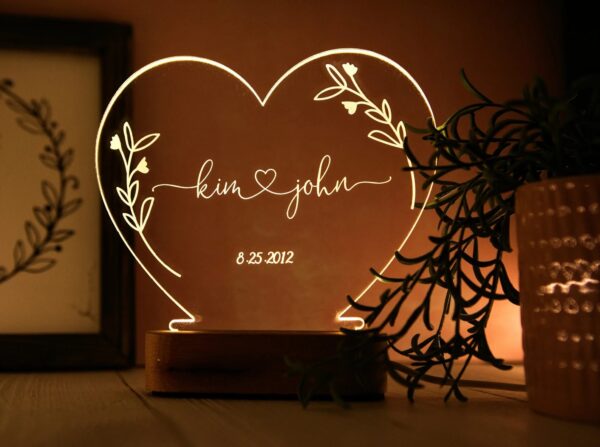 Photograph of a heart-shaped nightlight with the names Kim and John in the middle
