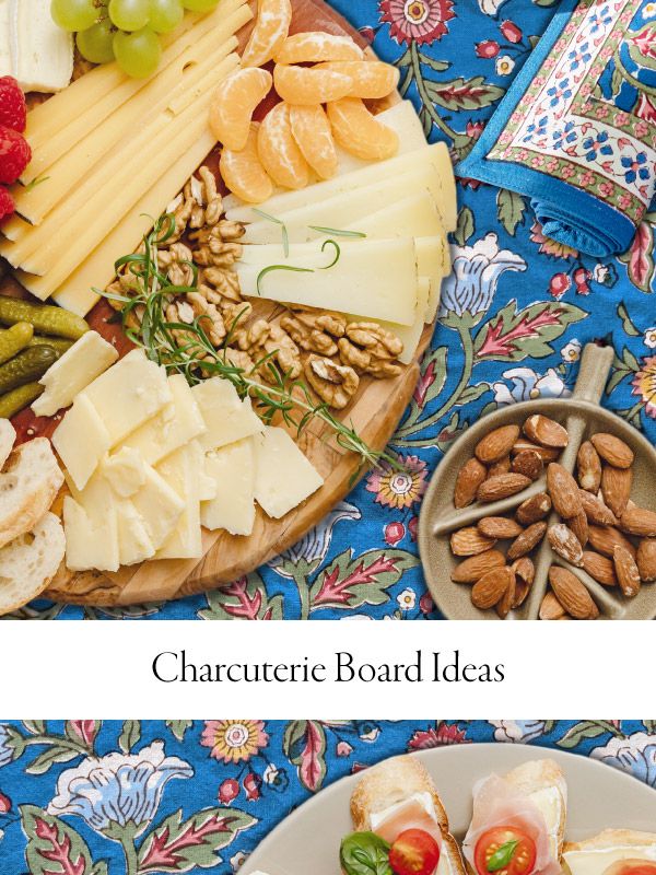 Photograph of a cheese, meat, and nut charctuerie board with overlaid text that reads "charcuterie board ideas" on a floral blue tablecloth