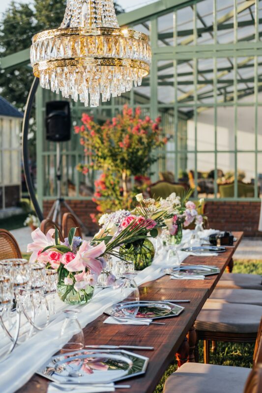 Photograph of table setting outdoors with floral arrangements and crystal utensils