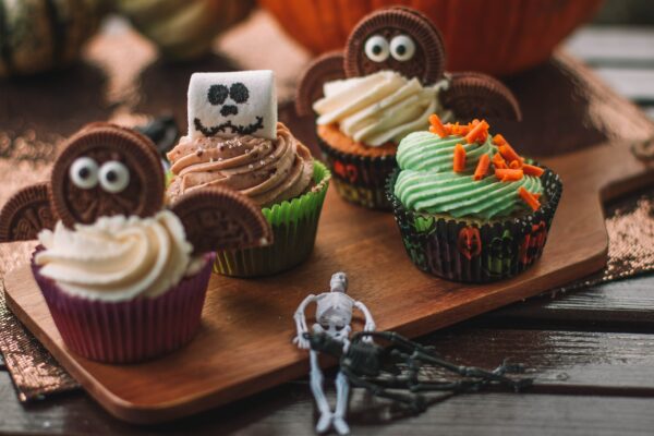 Photograph of a wooden serving tray with Halloween-themed cupcakes