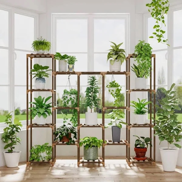 A large, tiered plant stand filled with plants of different sizes and shapes