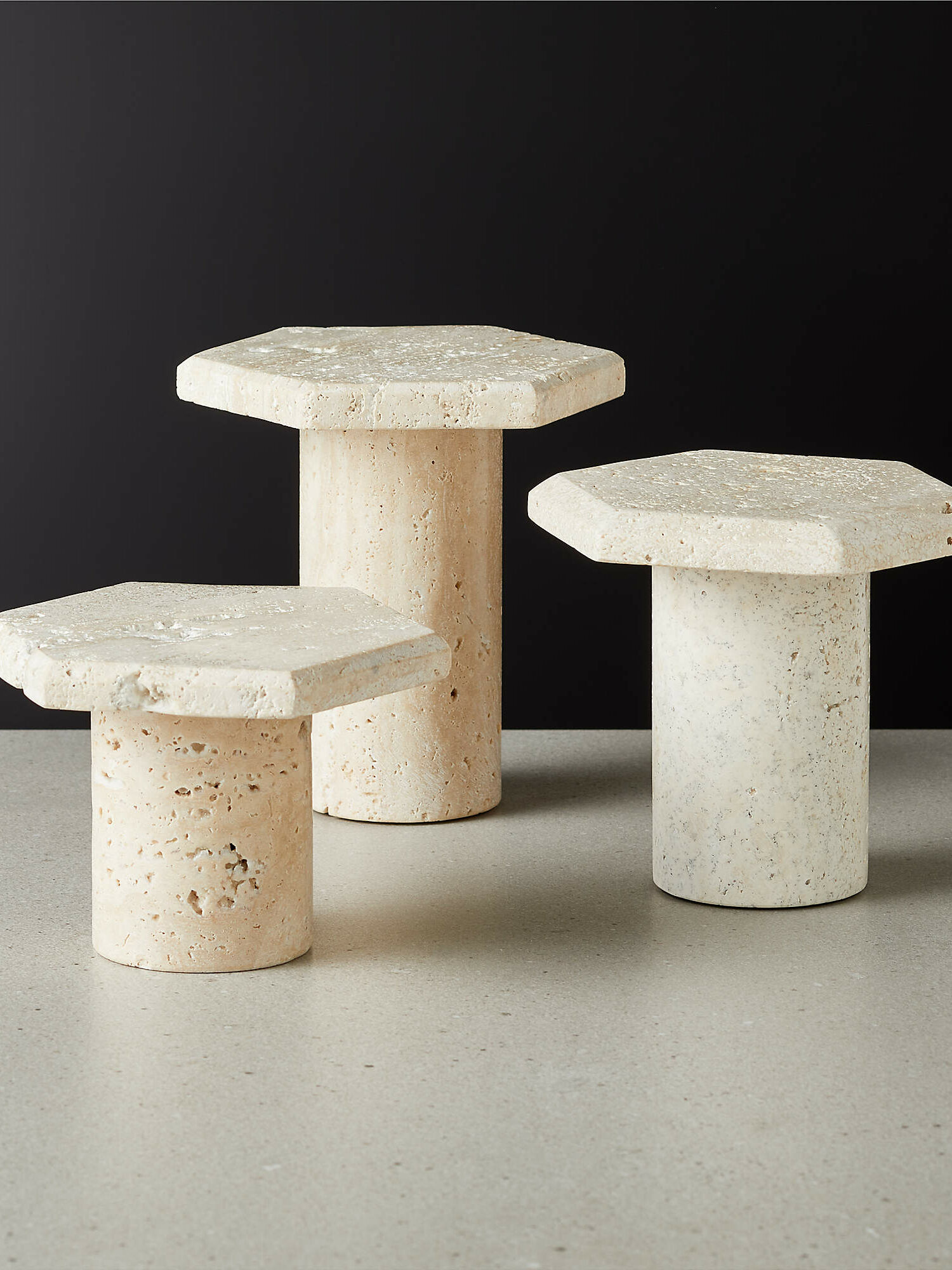 Travertine candle holder pedestals in a natural, sandy tone
