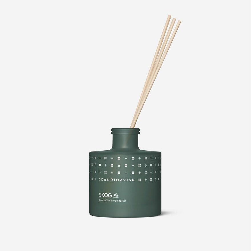 Photograph of a scent diffuser inside a deep green container