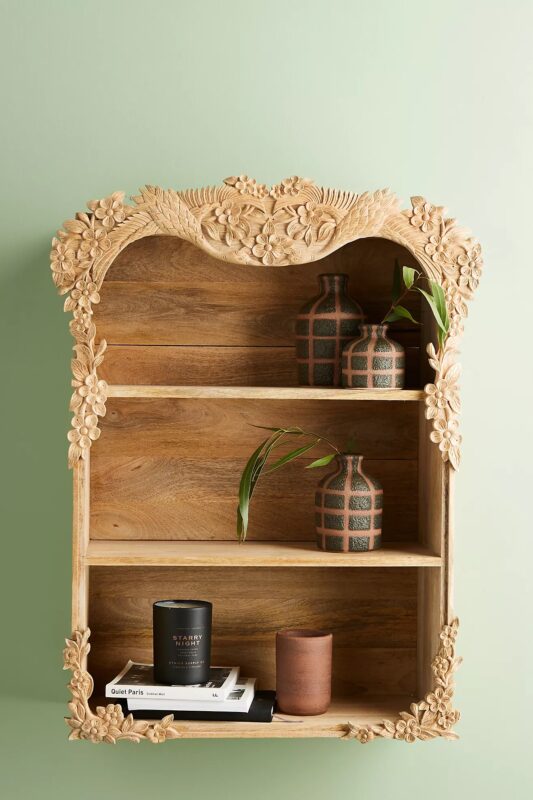 Simple shelf decor in an intricately carved mason type wall shelf