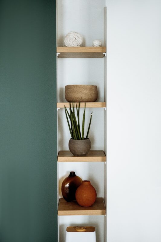 Photograph of a narrow, five-tier shelf display with simple shelf decor