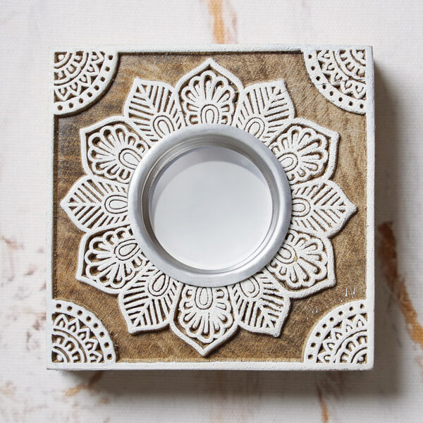 A hand-carved wooden tea light holder with a lotus flower design