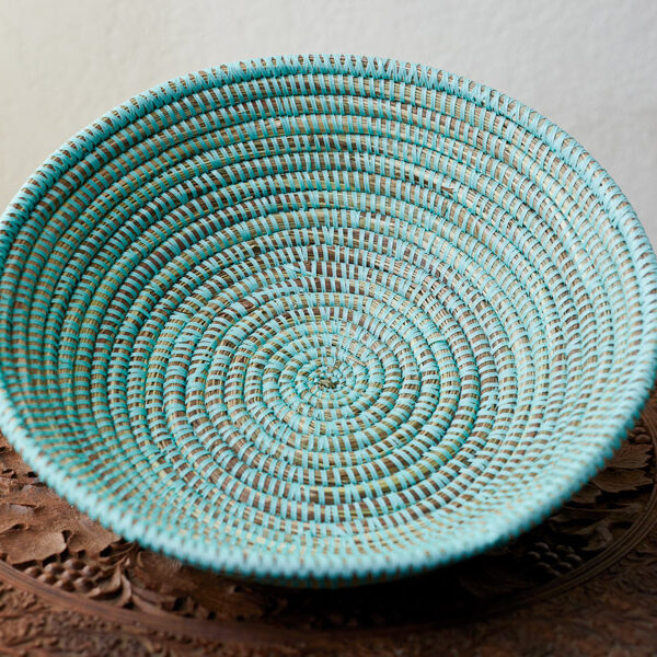 An empty turquoise woven basket 