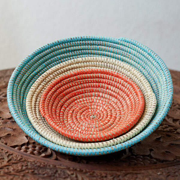 Nesting african woven baskets in three colors: light blue, natural, and red