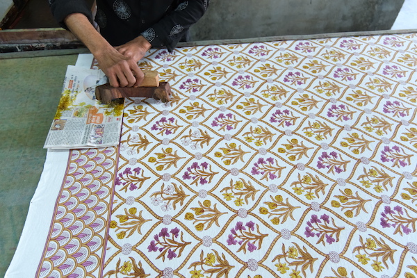 Photograph of artisan doing wood block printing on table