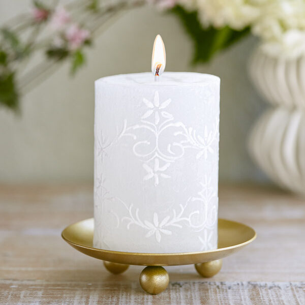 A white embossed candle to give an example of sophisticated white decor
