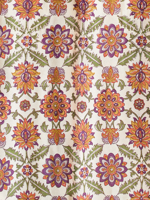 An orange, purple, cream, and green fabric swatch that can be used with white decor