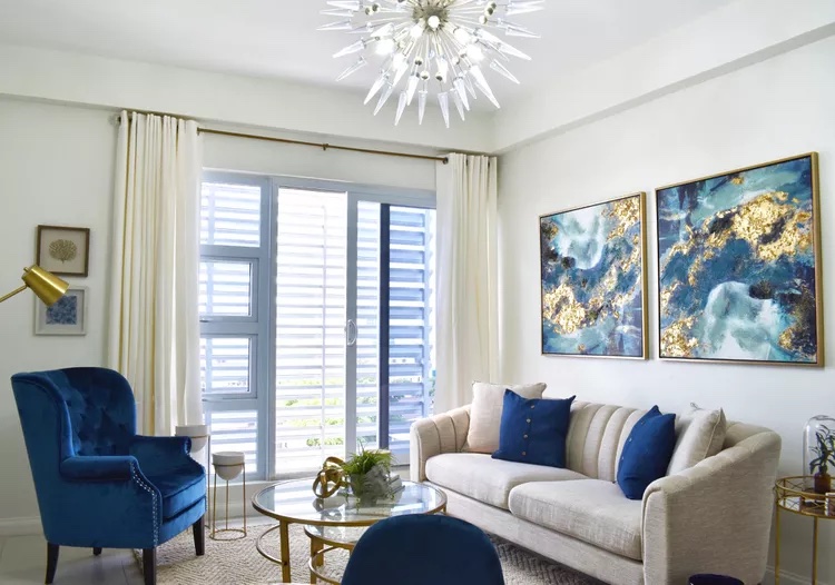Living room demonstrating blue and gold pop of color in a neutral white space