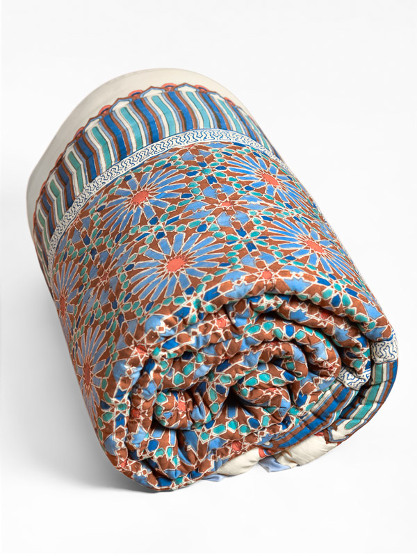 Photograph of a throw quilt demonstrating the idea of how to refresh a guest room with extra blankets