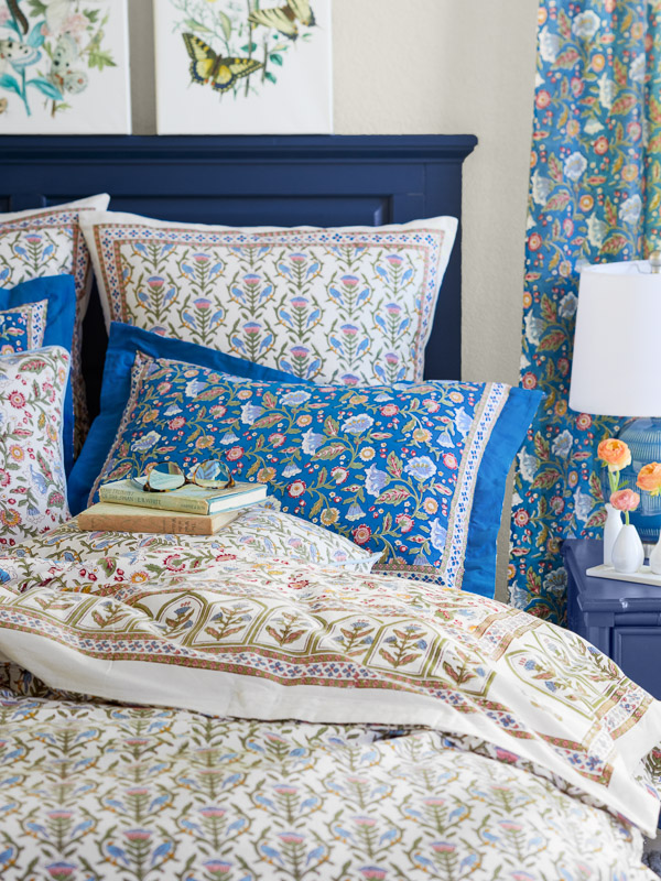 How to style a claming kid's room using linens in a floral pattern in soft pastels and soothing blue