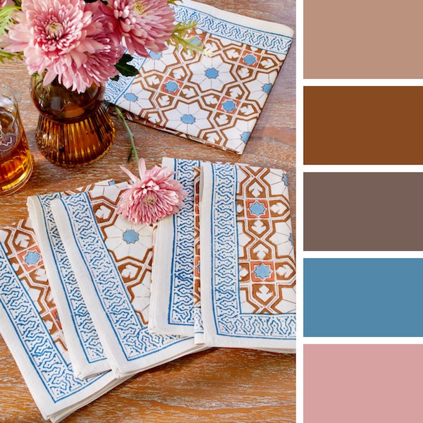 Photograph of a table setting with a palette collage of browns, blush pink, and French blue to demonstrate how to decorate for a winter wedding in a unique way