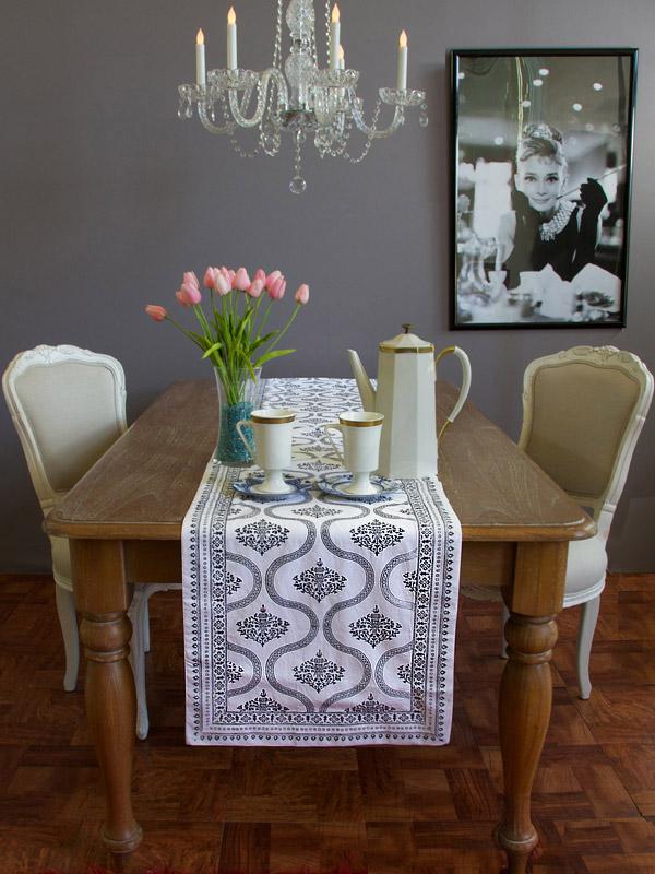 Photograph of a dining table with a transitional interior design style featuring an Old Hollywood black and white runner