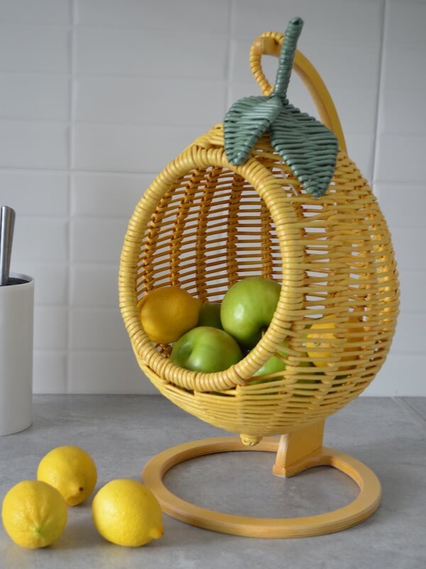 Photograph of a hanging fruit display in the shape and color of a lemon to demonstrate unique kitchen counter decor ideas