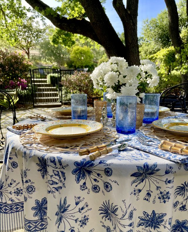 English cottage style garden with blue and white tablecloth and al fresco dining table